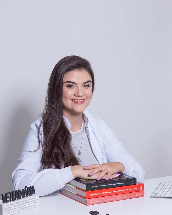 Dra. Kathy Alves com livros de medicina veterinária e estetoscópio