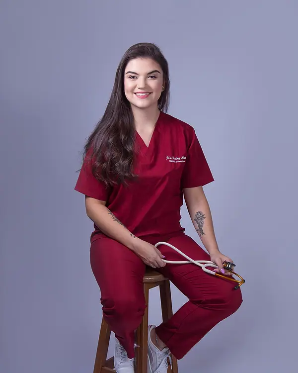 Dra. Kathy Alves sentada, com o estetoscópio na mão