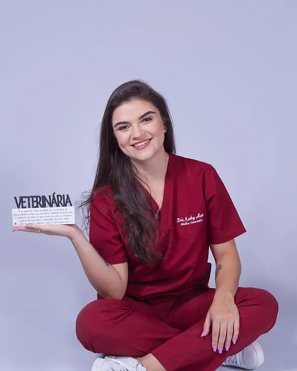 Dra. Kathy Alves segurando uma placa escrita Veterinária